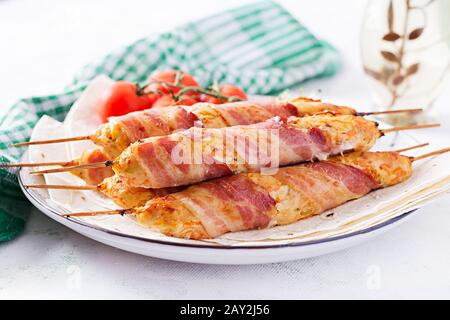 Lula kebab tritata tacchino grigliato (pollo) con zucca avvolta in pancetta su piastra. Foto Stock