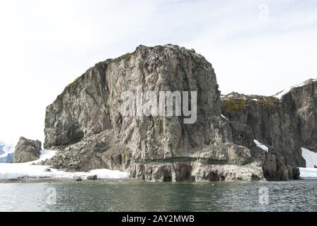 Roccia costa ea delle isole Antartiche in estate. Foto Stock