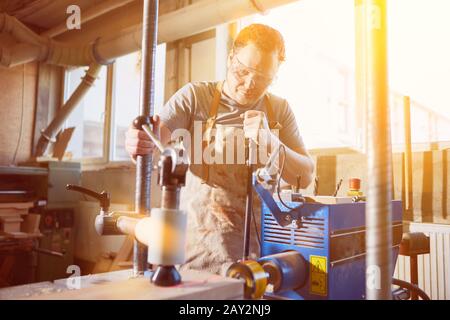 Schreiner utilizza un trapano moderno con display laser per perforare il legno nella Falegnameria Foto Stock