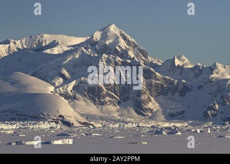 Montagne e oceano congelato con gli iceberg della Penisola Antartica Foto Stock