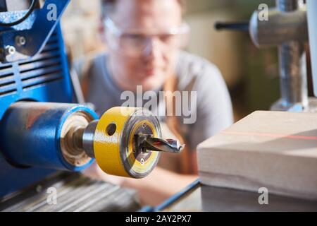 Carpentiere che perfora legno con display laser in carpenteria o Falegnameria Foto Stock