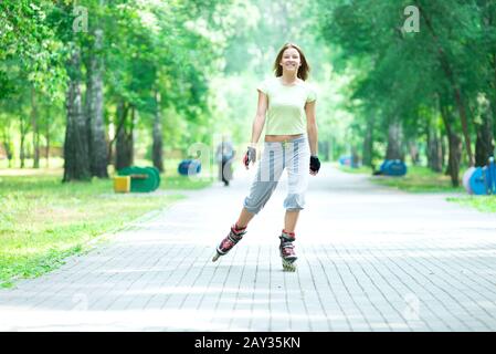 Roller Skating sportivo ragazza nel parco con i rollerblade sul pattino in linea Foto Stock