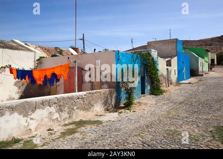 Strada pavimentata con colorato fresco lavato appese calcio lavanderia e case dipinte a Bofareira sull'isola Boa Vista di Capo Verde Foto Stock