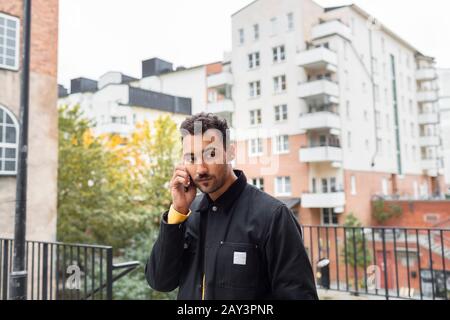 Uomo che parla tramite telefono cellulare Foto Stock