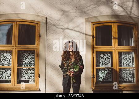 Donna felice che tiene bouquet di fiori Foto Stock
