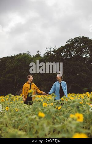 Coppia sul campo di girasole in fiore Foto Stock