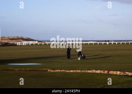 St ANDREWS, SCOTLAND - 13/2/2020 - UN golfista si prepara a scattare un colpo sul buco 18th del vecchio campo tra la scottatura di cigno e le sabbie occidentali Foto Stock