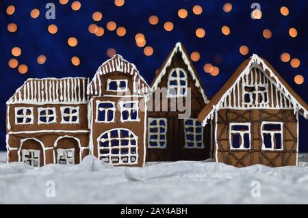 casa fatta città di pan di zenzero con cielo bokeh dal velluto blu e luci di natale come decorazione dell'avvento per la famiglia Foto Stock