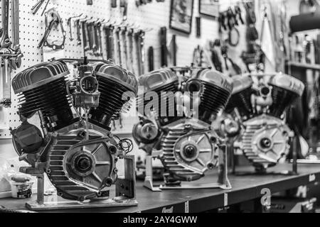 tre vecchi motori harley davidson esposti in un garage per motociclette. Foto Stock