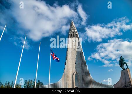 Cattedrale di Reykjavik in una giornata di sole con Islanda sventola bandiera. Foto Stock