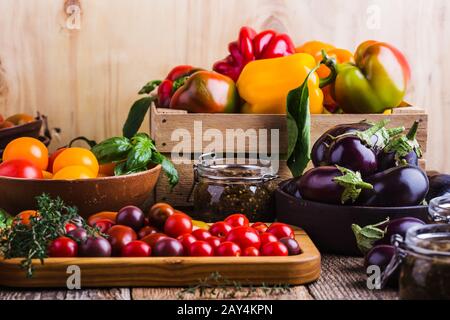 Varietà di verdure fresche colorate locali peperoni, pomodori, melanzane su tavola di legno, cibo a base di piante Foto Stock