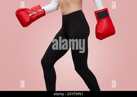 primo piano di una donna sportiva calzata indossando guanti da boxe, solo metà inferiore. Foto Stock