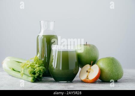 Colpo orizzontale di mele appena mescolate e cerely per il vostro consumo sano. Bevanda verde vegetariana in bicchieri. Bevande detox, frutta e verdura Foto Stock