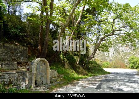 Vecchia fontana di pietra nella campagna per il cretese Foto Stock