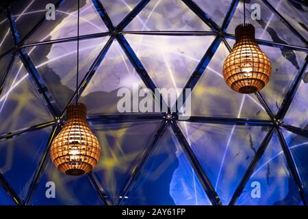 Coppia di due lampade in legno con luce calda e sfera blu terrestre sullo sfondo Foto Stock