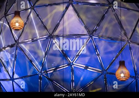 Coppia di due lampade in legno con luce calda e sfera blu terrestre sullo sfondo Foto Stock