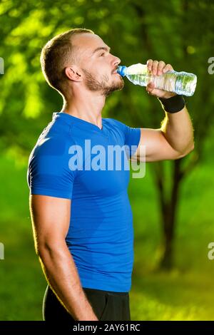 Athletic uomo maturo di bere acqua da una bottiglia Foto Stock