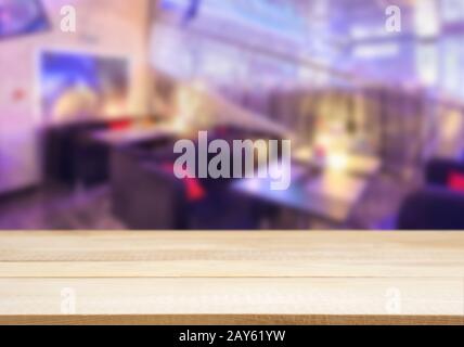 Tavola di legno tabella vuota nella parte anteriore del cafe sfocata Foto Stock