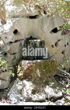 Vecchia fontana di pietra nella campagna per il cretese Foto Stock