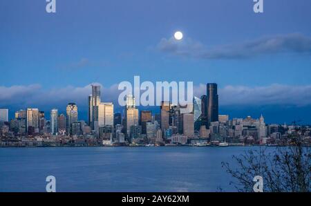 Una luna piena e luminosa splende sullo skyline di Seattle. Foto Stock