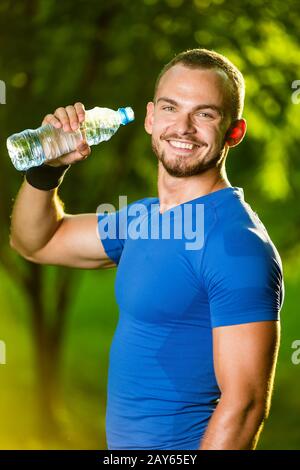 Athletic uomo maturo di bere acqua da una bottiglia Foto Stock