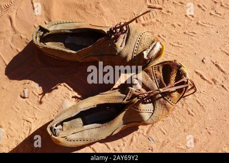 vecchio paio di scarpe sulla sabbia Foto Stock