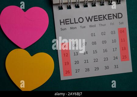 Vista dall'alto testo Hello Weekend su un Calendario isolato sulla scrivania dell'ufficio Foto Stock