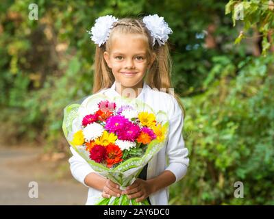 Su ritratto di un periodo di sette anni di scuola ragazza con un mazzo di fiori Foto Stock