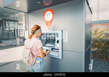 La donna asiatica ritira i soldi e paga il credito per lo studio alla strada europea ATM self-service macine Foto Stock