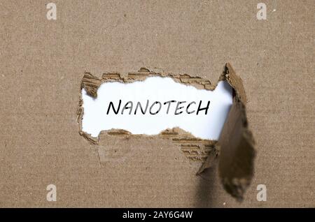 La parola nanotech che appaiono dietro di carta strappata Foto Stock