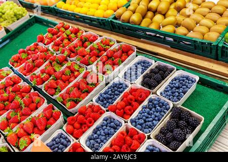 Una varietà di frutti di bosco e frutta in vendita sul mercato stradale Foto Stock