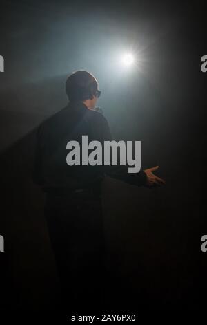 Uomo cantano on dark smoky stadio shot dal retro Foto Stock