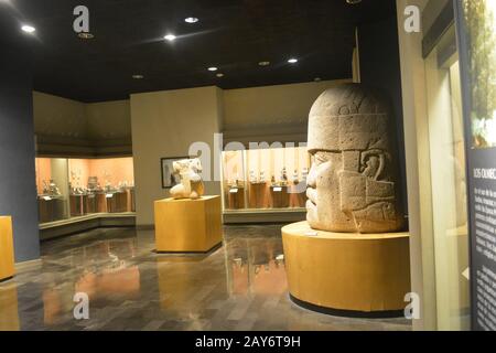 La testa di Olmec guarda l'uomo senza testa di Olmec inginocchiarsi da San Lorenzo. Vista dalla sala Olmec nel Museo Nazionale di Antropologia, Città del Messico Foto Stock