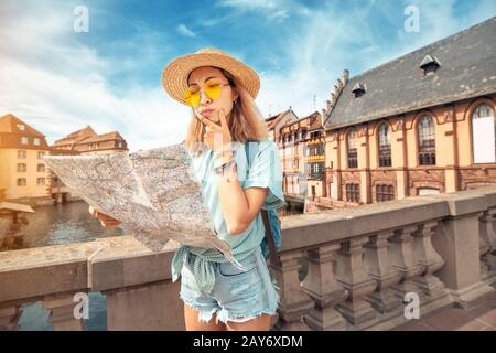 Donna asiatica confusa e persa che guarda la mappa nella città vecchia europea Foto Stock