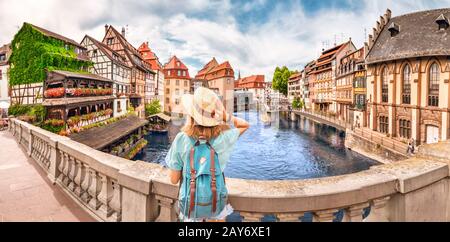 Giovane ragazza con zaino in piedi su un ponte sul fiume d Ill a Strasburgo, Francia Foto Stock