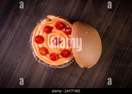 Hamburger doppio di manzo artigianale con formaggio cheddar, cipolla caramellata e pepe pout su tavola di legno e sfondo rustico Foto Stock