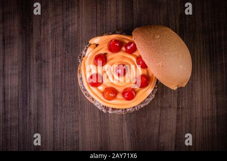 Hamburger doppio di manzo artigianale con formaggio cheddar, cipolla caramellata e pepe pout su tavola di legno e sfondo rustico Foto Stock