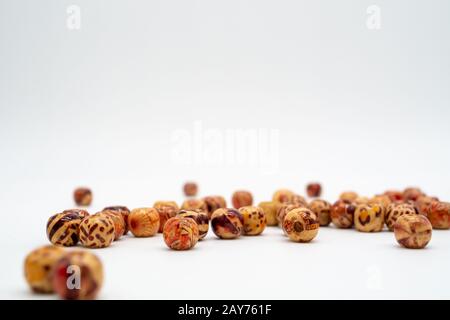 Perle decorate in legno sparse per artigianato. Perle di macramè. Modelli di stampa animale. Scatto da basso angolo.Isolato su sfondo bianco. Foto Stock