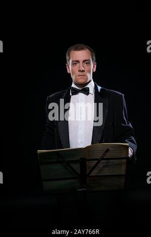 Orchestra in nero Tuxedo in dark studio Foto Stock