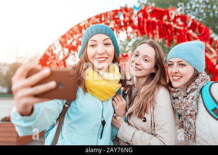 Tre migliori amici ragazze posa e scattare una foto selfie sullo smartphone durante il viaggio in autunno. Concetto di sistema Foto Stock