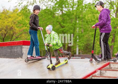 3 maggio 2019, Mosca, Russia: I bambini fanno un giro in scooter in uno skatepark su rampe e fanno alcuni trucchi Foto Stock