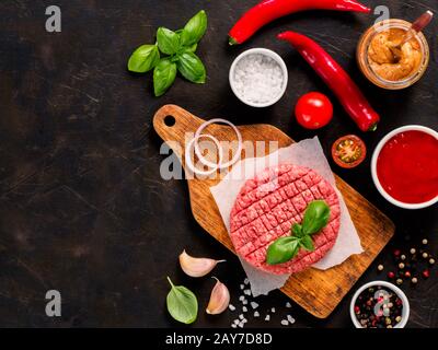 Bistecca di manzo cruda per hamburger con spezie e verdure Foto Stock