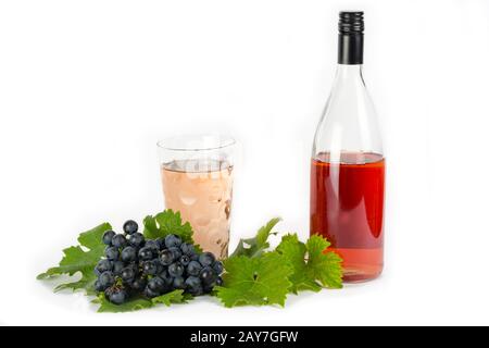 Vino rosso con picchi di rosso e uva isolato su bianco Foto Stock