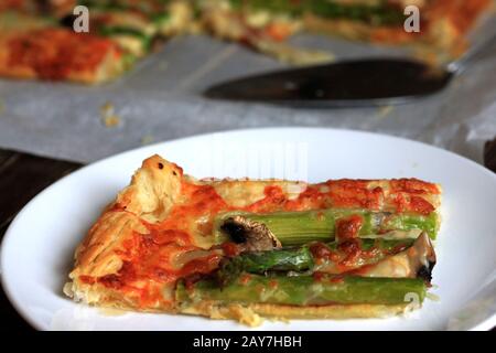 Pasta sfoglia con asparagi e formaggio. Uno spuntino delizioso e veloce con pasta sfoglia. Una cena perfetta e gustosa. Foto Stock