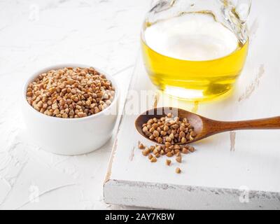 Brown del grano saraceno in cucchiaio e grano saraceno olio vicino fino Foto Stock