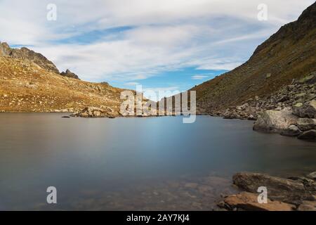 Paesaggio notturno di un alto lago di montagna sotto il chiaro di luna Foto Stock