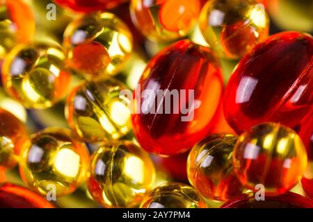 Giallo e rosso capsule medico su una superficie a specchio Foto Stock