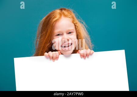 Cute bellezza bambina in maglietta con capelli lunghi tenere carta pulita Foto Stock