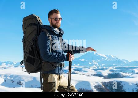 Un viaggiatore hippster con una barba che indossa occhiali da sole in natura. Foto Stock