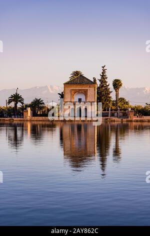 Il Menara Gardens Pavilion si riflette nell'acqua al tramonto, in Marocco Foto Stock